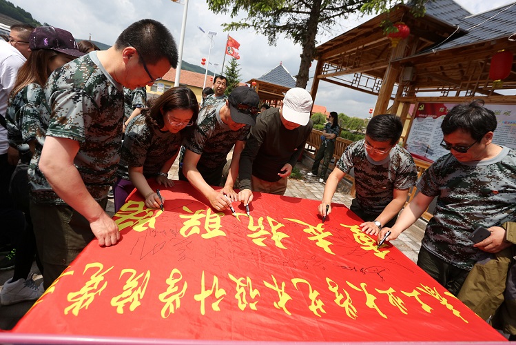 党员师生在重走抗联路旗帜上签名留念.jpg 党员师生在重走抗联路旗帜上签名留念.jpg